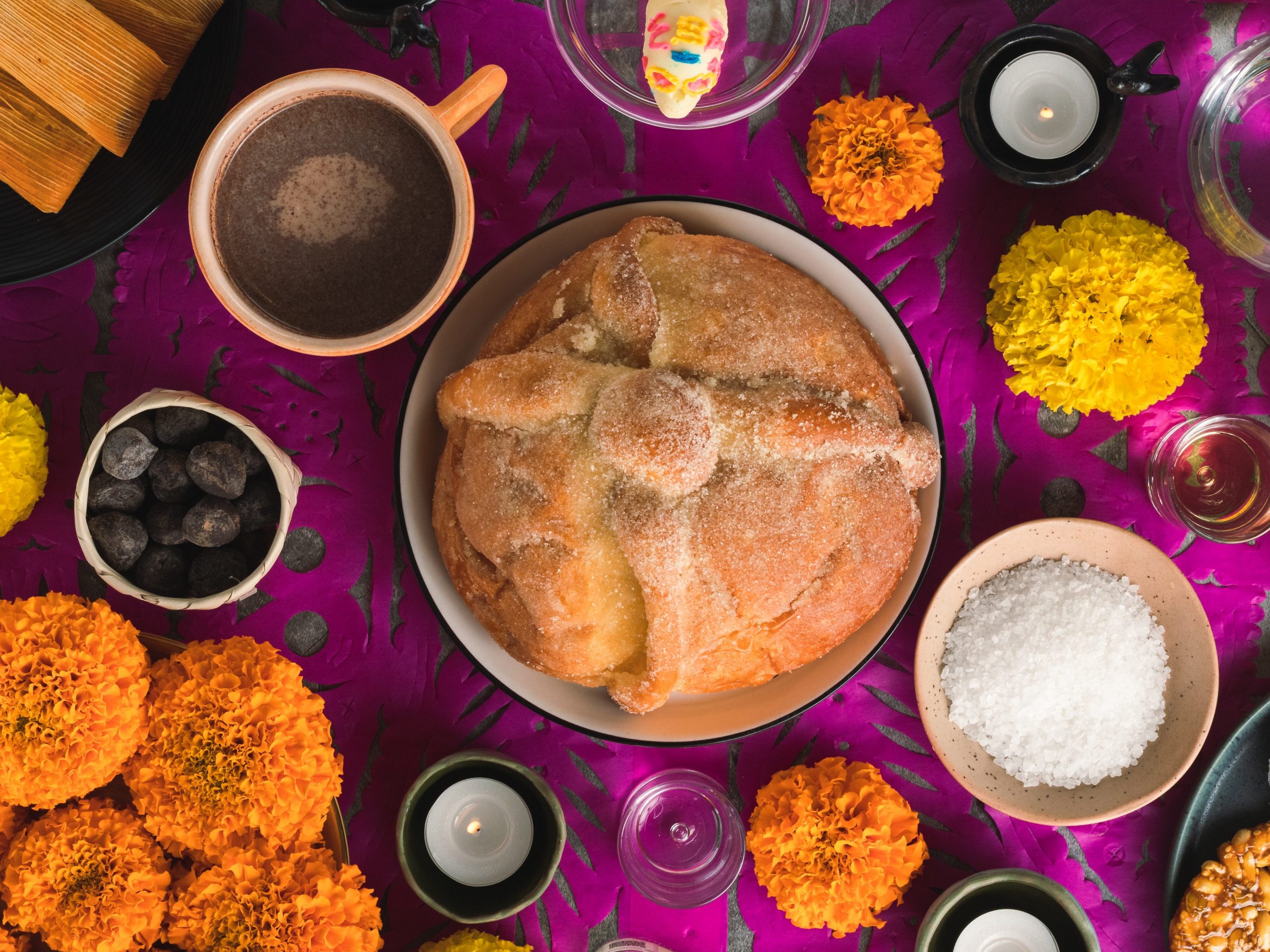 pan de muerto, veladoras, sal, flores, chocolate y papel picado, elementos de un altar de muertos